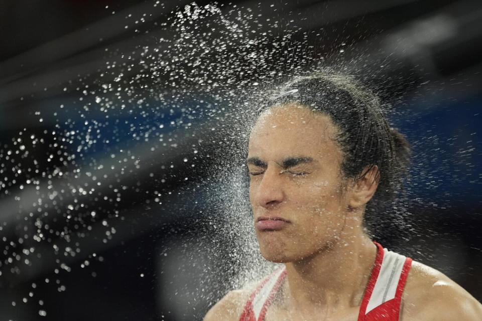 Algerian boxer Imane Khelif is sprayed with water prior to her fight against Yang Liu, of China, during the Olympics.