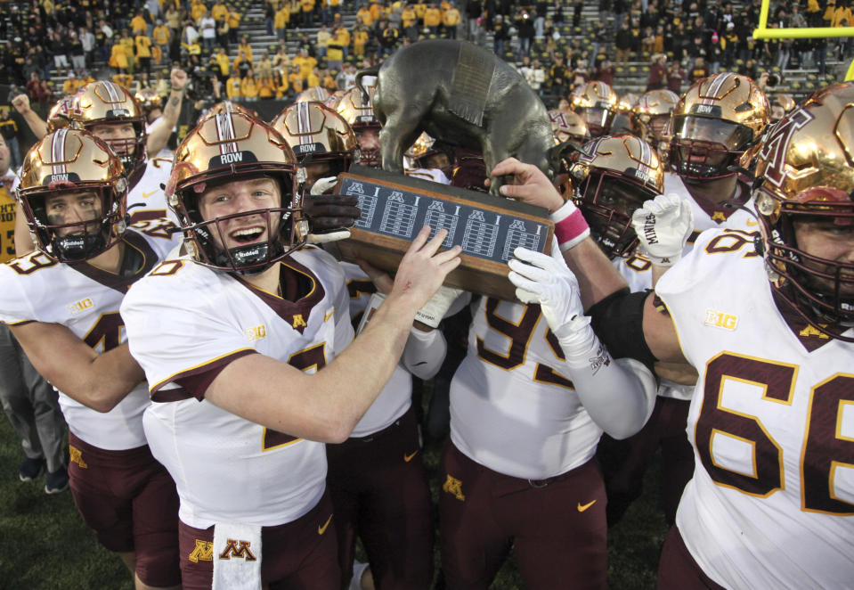 IOWA CITY, IOWA- OCTOBER 21: Quarterback Athan Kaliakmanis #8 of the Minnesota Golden Gophers celebrates with teammates as they take the Floyd of Rosedale trophy after their match-up against the Iowa Hawkeyes at Kinnick Stadium on October 21, 2023 in Iowa City, Iowa. (Photo by Matthew Holst/Getty Images)