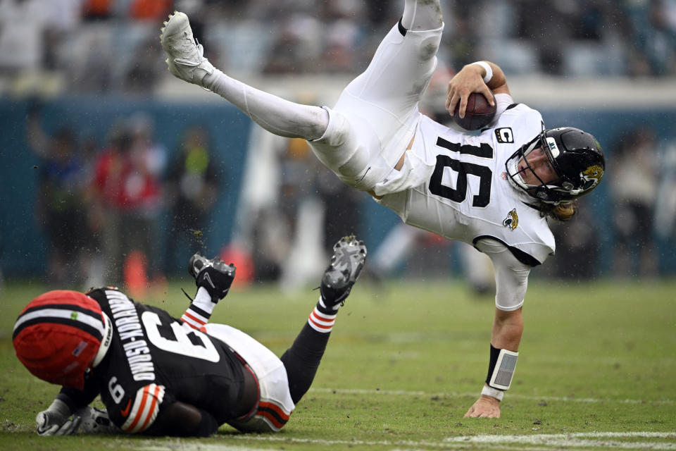 Jacksonville Jaguars quarterback Trevor Lawrence (16) leaps over Cleveland Browns linebacker Jeremiah Owusu-Koramoah (6) on a run during the second half of an NFL football game Sunday, Sept. 15, 2024, in Jacksonville, Fla. (AP Photo/Phelan M. Ebenhack)