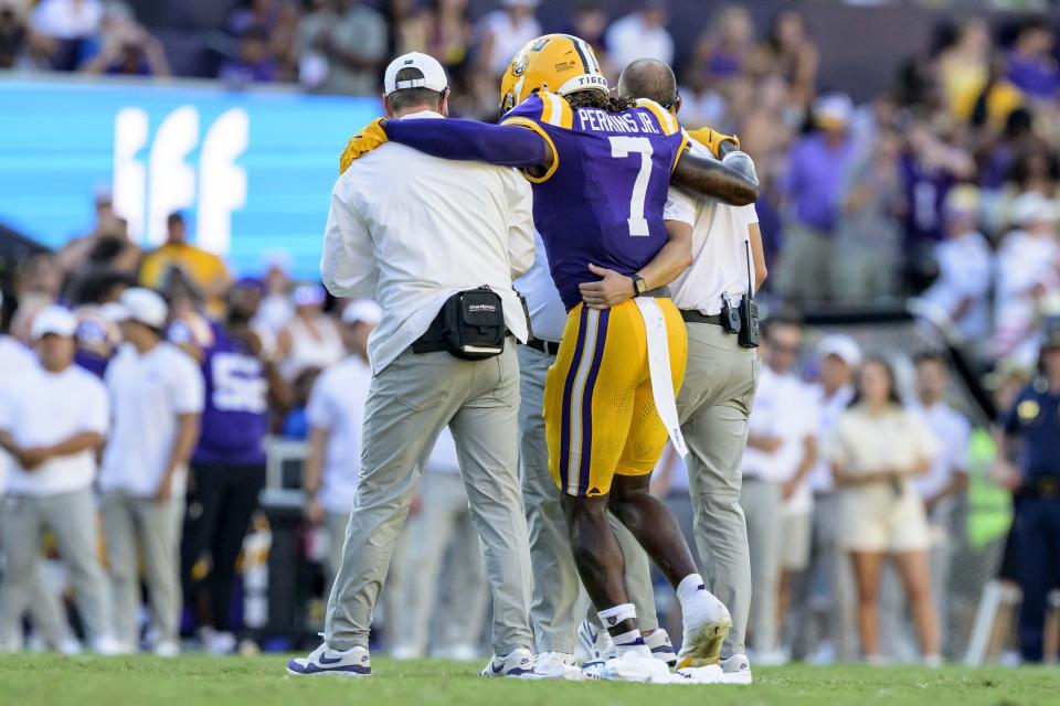 LSU linebacker Harold Perkins Jr. (7) is helped off the field after a collision with UCLA wide receiver J.Michael Sturdivant (7) in the second half of an NCAA football game on Saturday, Sept. 21, 2024, in Baton Rouge, La. (AP Photo/Matthew Hinton)