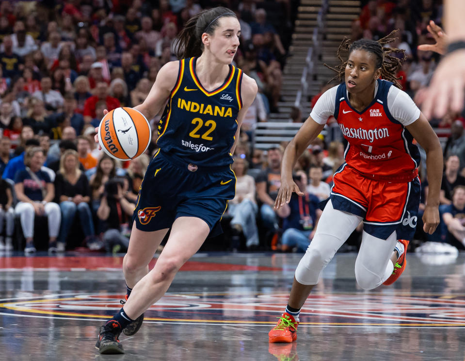 INDIANAPOLIS, INDIANA - JULY 10: Caitlin Clark #22 of the Indiana Fever dribbles against Ariel Atkins #7 of the Washington Mystics at Gainbridge Fieldhouse on July 10, 2024 in Indianapolis, Indiana. NOTE TO USER: User expressly acknowledges and agrees that, by downloading and or using this photograph, User is consenting to the terms and conditions of the Getty Images License Agreement. (Photo by Michael Hickey/Getty Images)