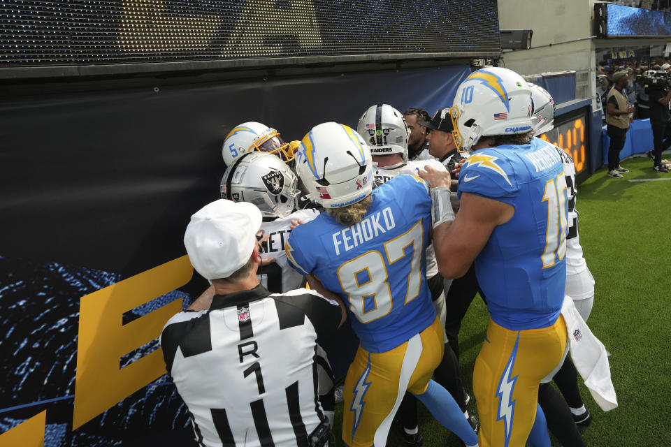 Officials try to separate players from the Los Angeles Chargers and the Las Vegas Raiders during the second half of an NFL football game, Sunday, Sept. 8, 2024, in Inglewood, Calif. (AP Photo/Marcio Jose Sanchez)