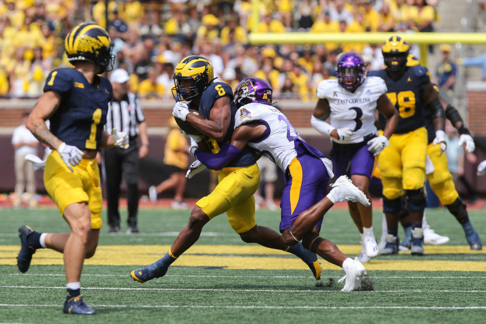 ANN ARBOR, MI - SEPTEMBER 02: Michigan Wolverines wide receiver Cornelius Johnson (6) runs with the ball after catching a pass while trying to avoid being tackled by East Carolina Pirates defensive back Shavon Revel (28) during the third quarter of a non-conference college football game between the East Carolina Pirates and the Michigan Wolverines on September 2, 2023 at Michigan Stadium in Ann Arbor, Michigan. (Photo by Scott W. Grau/Icon Sportswire via Getty Images)