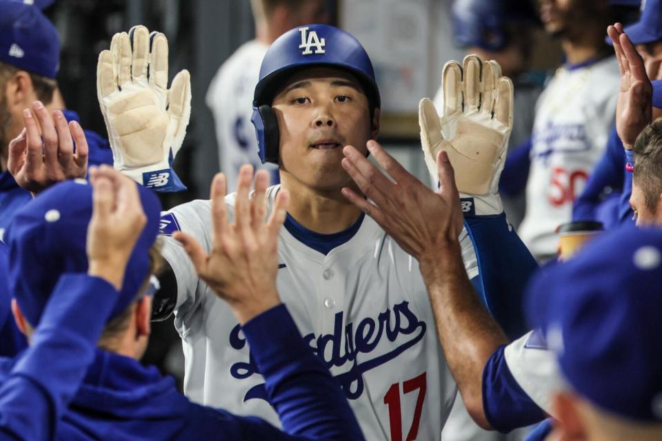 Shohei Ohtani celebrates in the dugout after scoring against the Padres.