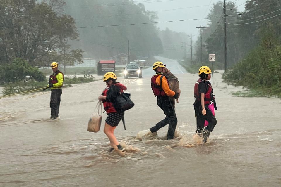 A swift water rescue worker carries a pet dog on Friday in Boone, North Carolina (REUTERS/Jonathan Drake)