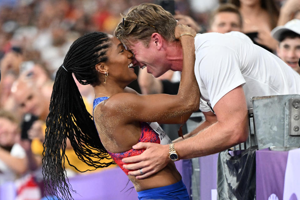 Gold medallist US' Tara Davis-Woodhall (L) celebrates with her husband US' track and field paralympic athlete Hunter Woodhall (R) after winning the women's long jump final of the athletics event at the Paris 2024 Olympic Games at Stade de France in Saint-Denis, north of Paris, on August 8, 2024. (Photo by Kirill KUDRYAVTSEV / AFP) (Photo by KIRILL KUDRYAVTSEV/AFP via Getty Images)