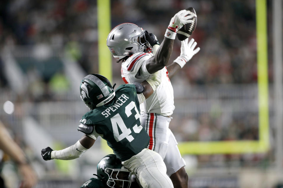 Ohio State wide receiver Jeremiah Smith, right, catches a pass for a first down against Michigan State defensive back Malik Spencer (43) during the first half of an NCAA college football game, Saturday, Sept. 28, 2024, in East Lansing, Mich. (AP Photo/Al Goldis)