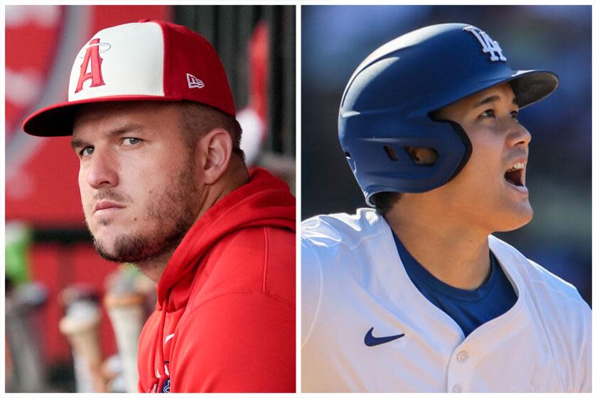 Los Angeles Angels center fielder Mike Trout, from left, sits in the dugout during the first inning of a baseball game against the New York Mets, Friday, Aug. 2, 2024, in Anaheim, Calif. Los Angeles Dodgers dh Shohei Ohtani (17) homers off Colorado Rockies pitcher Seth Halvorsen (54) in the ninth inning to tie the game at Dodger Stadium. (AP Photo/Ryan Sun, Robert Gauthier/Los Angeles Times)