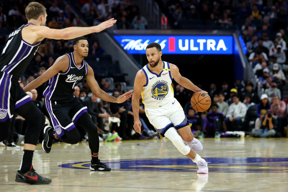 SAN FRANCISCO, CALIFORNIA - OCTOBER 11: Stephen Curry #30 of the Golden State Warriors is guarded by Domantas Sabonis #11 and Keegan Murray #13 of the Sacramento Kings during their preseason game at Chase Center on October 11, 2024 in San Francisco, California. NOTE TO USER: User expressly acknowledges and agrees that, by downloading and/or using this photograph, user is consenting to the terms and conditions of the Getty Images License Agreement. (Photo by Ezra Shaw/Getty Images)