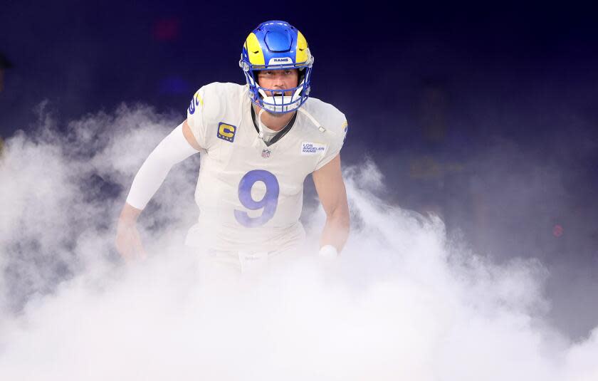 Rams quarterback Matthew Stafford runs through smoke during introductions before a home game.