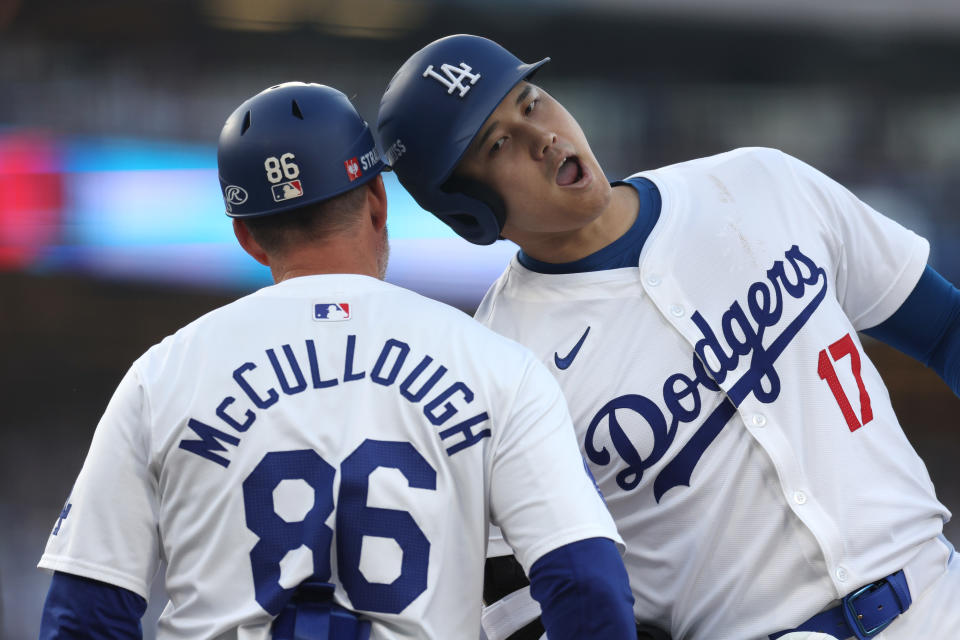 LOS ANGELES, CALIFORNIA - OCTOBER 13: First base coach Clayton McCullough and Shohei Ohtani #17 of the Los Angeles Dodgers celebrate after Ohtani hit a single in the second inning against the New York Mets during Game One of the Championship Series at Dodger Stadium on October 13, 2024 in Los Angeles, California. (Photo by Harry How/Getty Images)