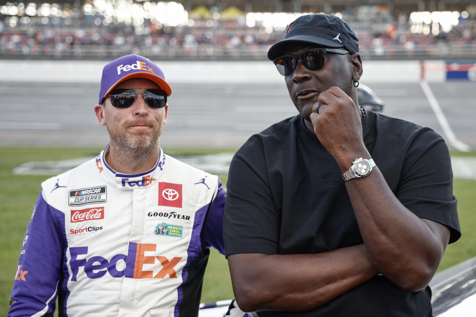 TALLADEGA, ALABAMA - OCTOBER 06: Co-owners of 23XI Racing, Denny Hamlin, driver of the #11 FedEx One Rate Toyota, and NBA Hall of Famer, Michael Jordan talk on the grid after the NASCAR Cup Series YellaWood 500 at Talladega Superspeedway on October 06, 2024 in Talladega, Alabama. (Photo by Chris Graythen/Getty Images)