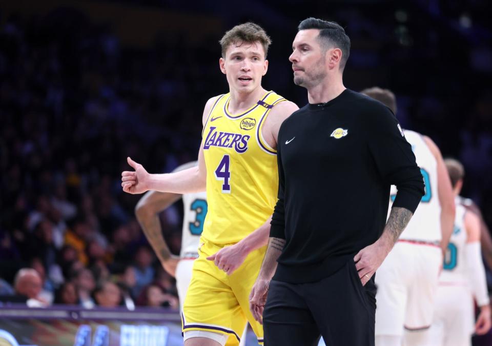 Lakers rookie Dalton Knecht talks with coach JJ Redick during a break in play