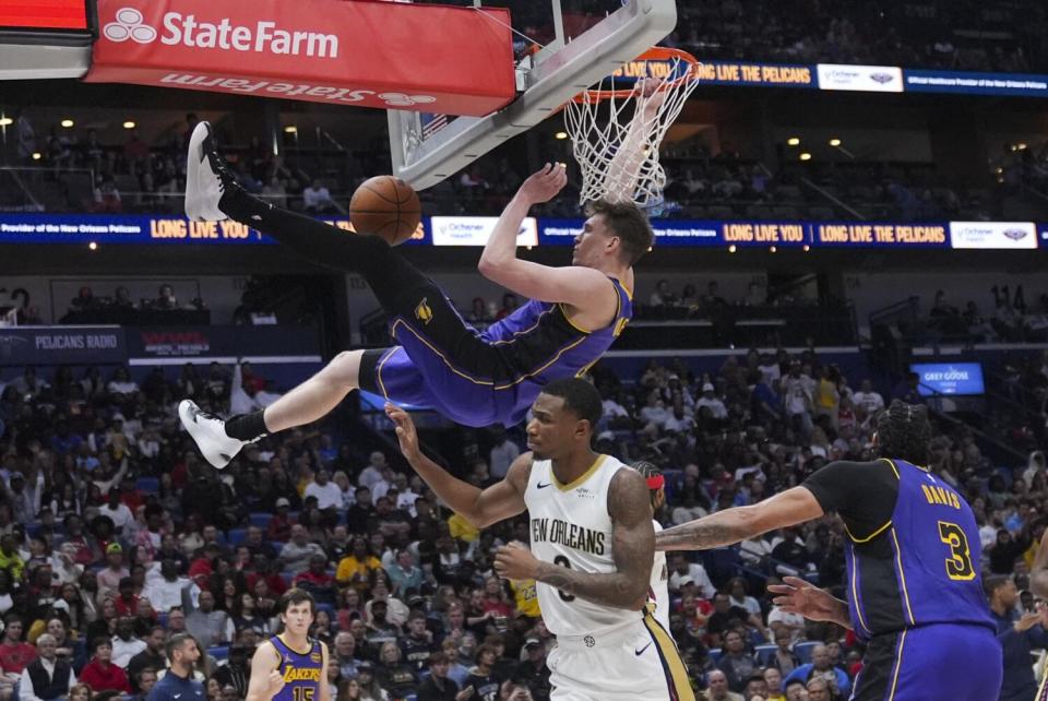 Lakers guard Dalton Knecht hangs on the rim after a dunk