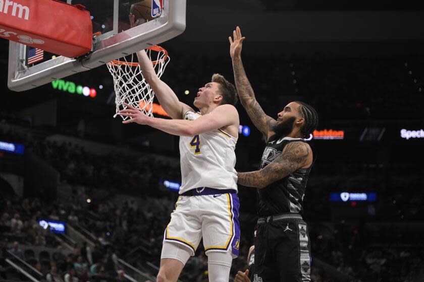 Los Angeles Lakers' Dalton Knecht (4) goes to the basket against San Antonio Spurs' Julian Champagnie during the first half of an Emirates NBA Cup basketball game, Friday, Nov. 15, 2024, in San Antonio. (AP Photo/Darren Abate)