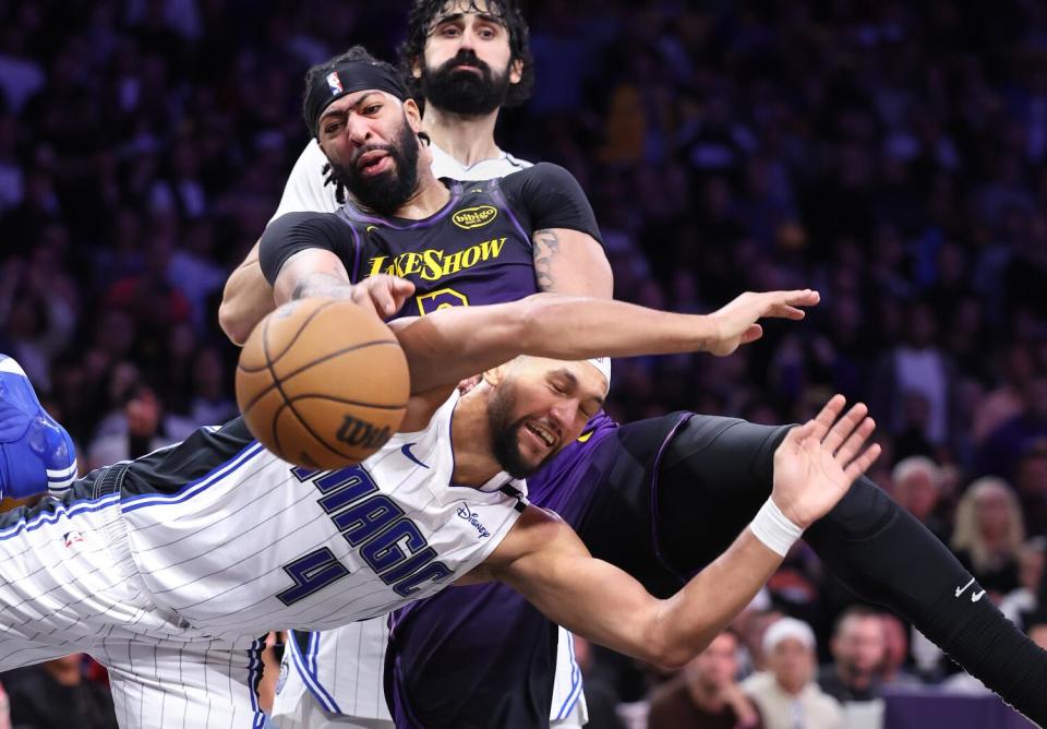 Lakers forward Anthony Davis and Orlando's Jalen Suggs, front, battle for a rebound in the fourth quarter Thursday.