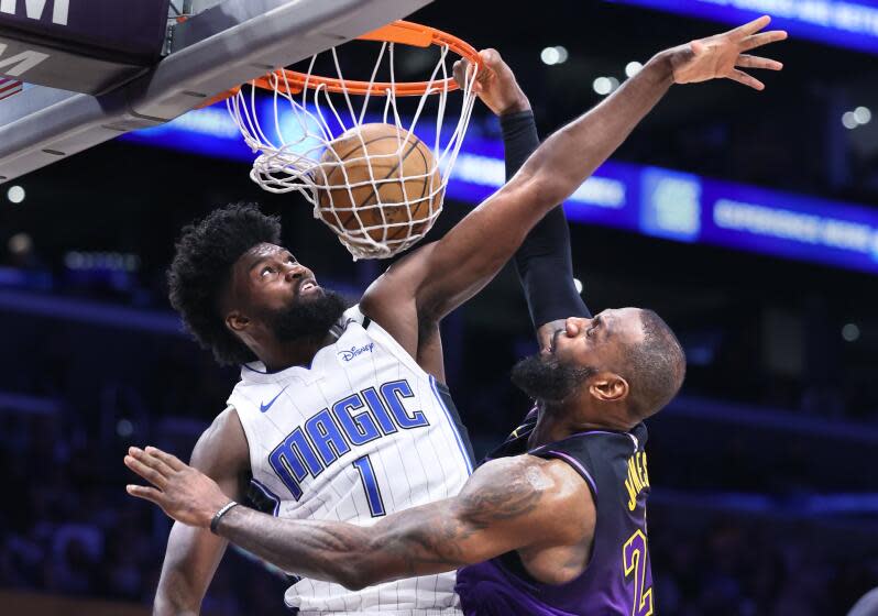 Lakers LeBron James dunks over Magic's Jonathan Isaac.