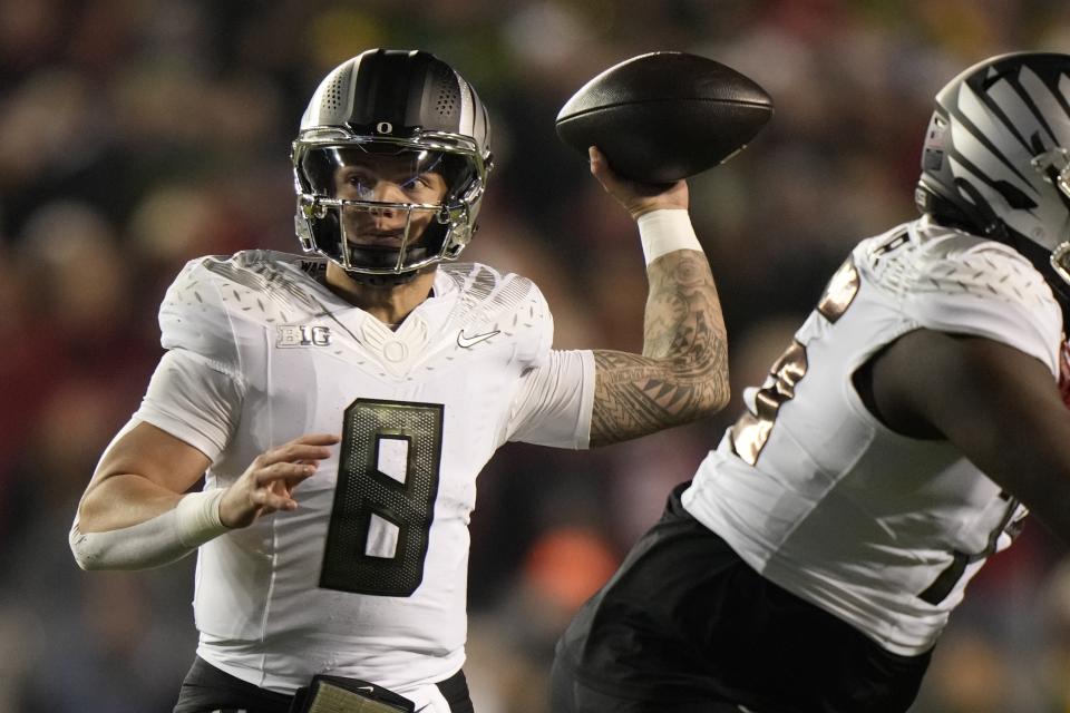 Oregon's Dillon Gabriel (8) thorws a pass during the first half of an NCAA college football game against Wisconsin Saturday, Nov. 16, 2024, in Madison, Wis. (AP Photo/Morry Gash)