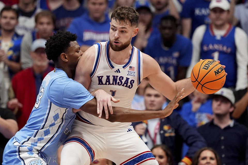 North Carolina forward Jalen Washington, left, tries to steal the ball from Kansas center Hunter Dickinson (1) during the second half of an NCAA college basketball game Friday, Nov. 8, 2024, in Lawrence, Kan. Kansas won 92-89. (AP Photo/Charlie Riedel)