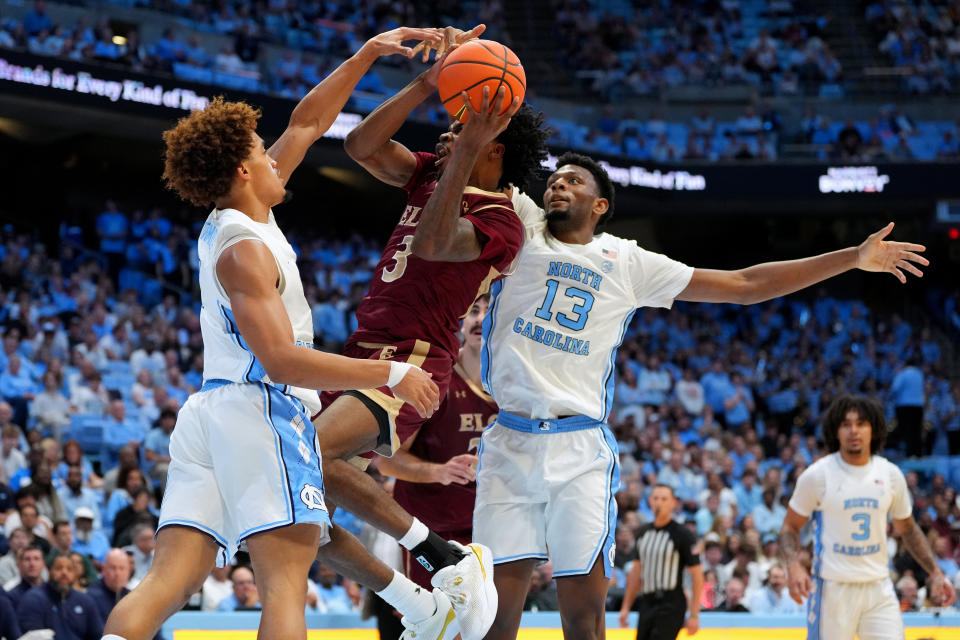 CHAPEL HILL, NORTH CAROLINA - NOVEMBER 04: TK Simpkins #3 of the Elon Phoenix drives to the basket between Seth Trimble #7 and Jalen Washington #13 of the North Carolina Tar Heels during the first half of the game at the Dean E. Smith Center on November 04, 2024 in Chapel Hill, North Carolina. (Photo by Grant Halverson/Getty Images)