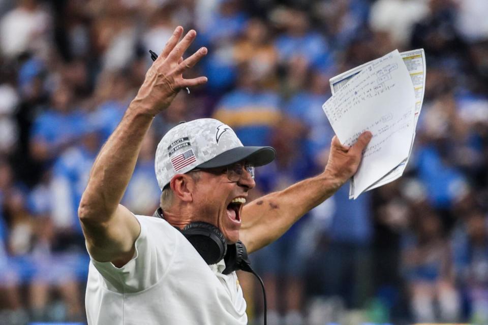 Chargers coach Jim Harbaugh celebrates a touchdown against the Titans.