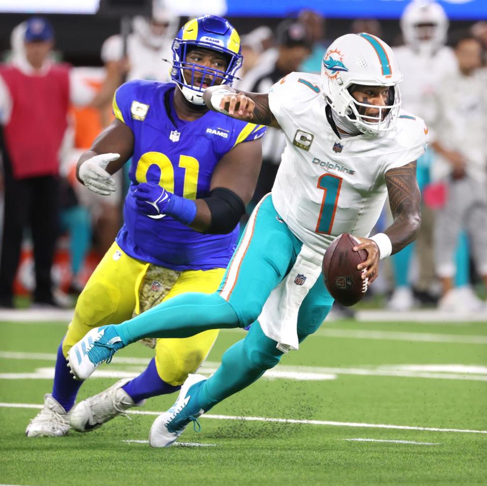 Dolphins quarterback Tua Tagovailoa avoids the sack attempt by the Rams' Kobie Turner.