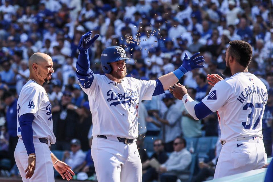 Dodgers third baseman Max Muncy is showered by sunflower seeds tossed by Teoscar Hernández after hitting a homer