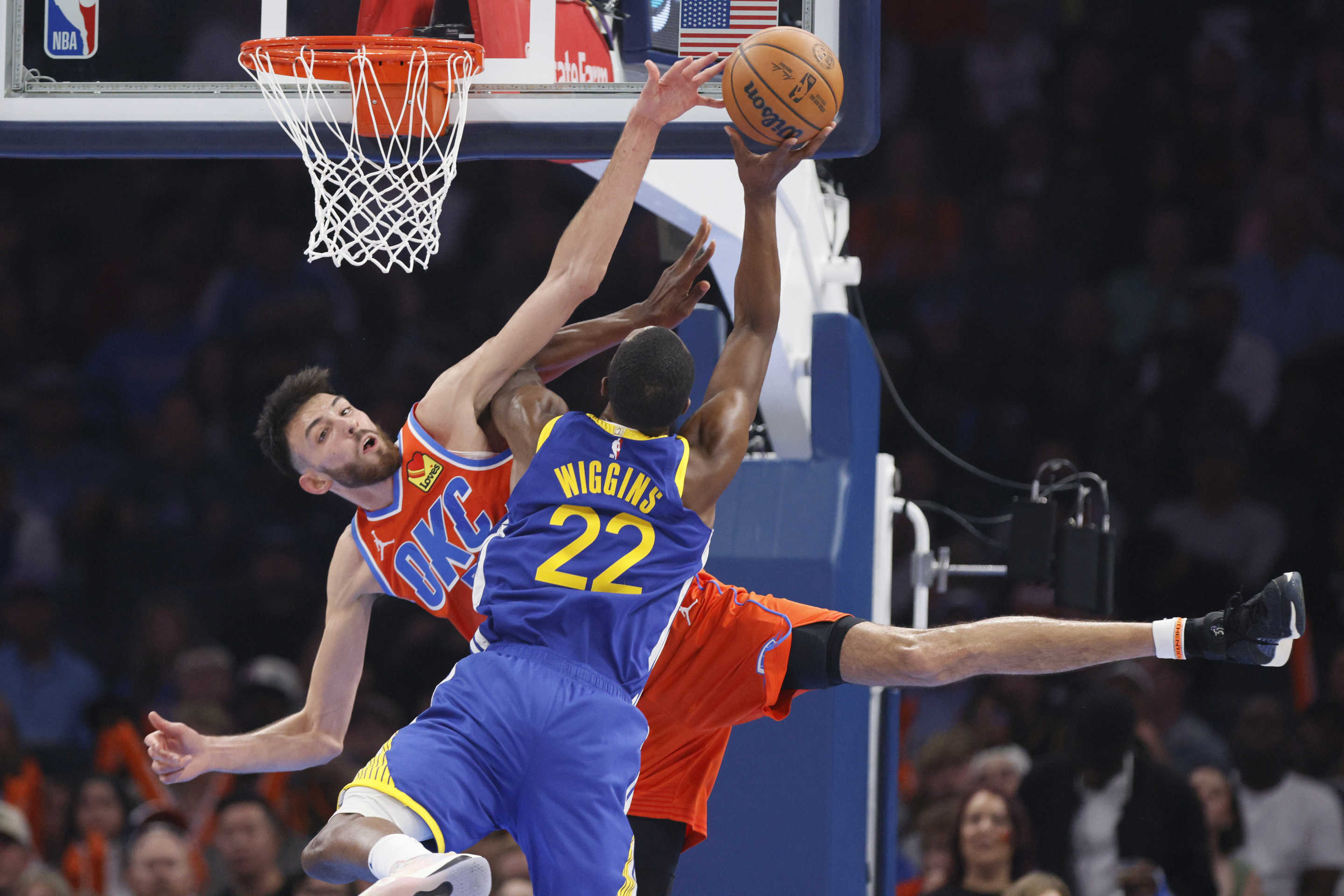 Oklahoma City Thunder forward Chet Holmgren, left, and Golden State Warriors forward Andrew Wiggins (22) collide as Wiggins shoots during the first half of an NBA basketball game Sunday, Nov. 10, 2024, in Oklahoma City. Holmgren was injured on the play and helped off the court. (AP Photo/Nate Billings)