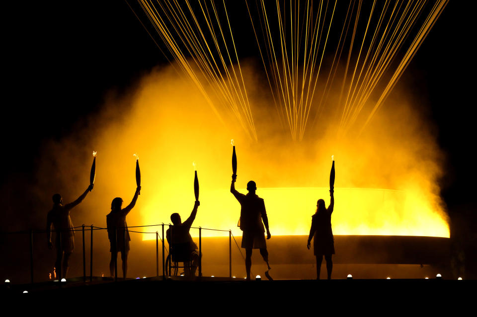 PARIS, FRANCE - AUGUST 28: Torchbearers Charles-Antoine Kouakou, Fabien Lamirault, Élodie Lorandi, Nantenin Keïta and Alexis Hanquinquant gesture after lighting the Cauldron to conclude the Opening Ceremony of the Paris 2024 Summer Paralympic Games at Place de la Concorde on August 28, 2024 in Paris, France. (Photo by David Ramos/Getty Images)