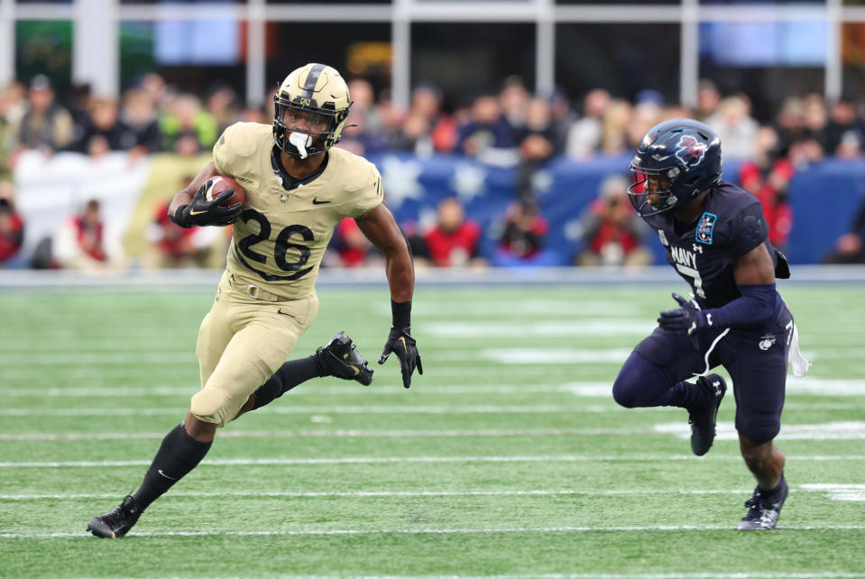 FOXBOROUGH, MA - DECEMBER 09: Army Black Knights running back Kanye Udoh (26) pursued by Navy Midshipmen defensive end Mbiti Williams Jr. (7) during the 124th Army-Navy football game on December 9, 2023, at Gillette Stadium in Foxborough, MA. (Photo by M. Anthony Nesmith/Icon Sportswire via Getty Images)