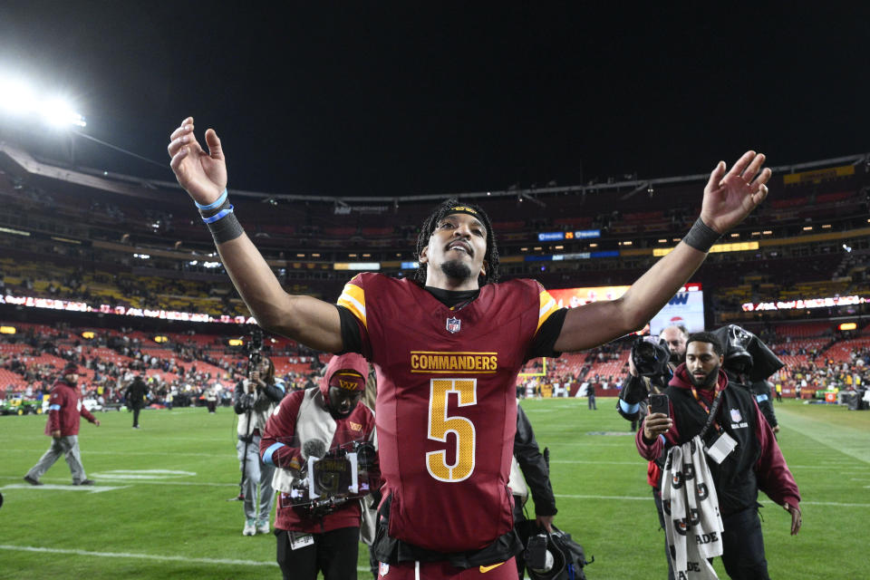 Washington Commanders quarterback Jayden Daniels (5) celebrates after winning over the Atlanta Falcons in overtime during an NFL football game, Sunday, Dec. 29, 2024, in Landover, Md. The Commanders won 30-24. (AP Photo/Nick Wass)