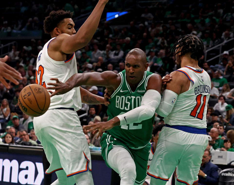 Boston Celtics center Al Horford (42) dishes off the pass between New York Knicks center Karl-Anthony Towns (32) and New York Knicks guard Jalen Brunson (11) as the Celtics raise their championship banner before their game against the Knicks on October 22. (Staff Photo By Stuart Cahill/Boston Herald via Getty Images)