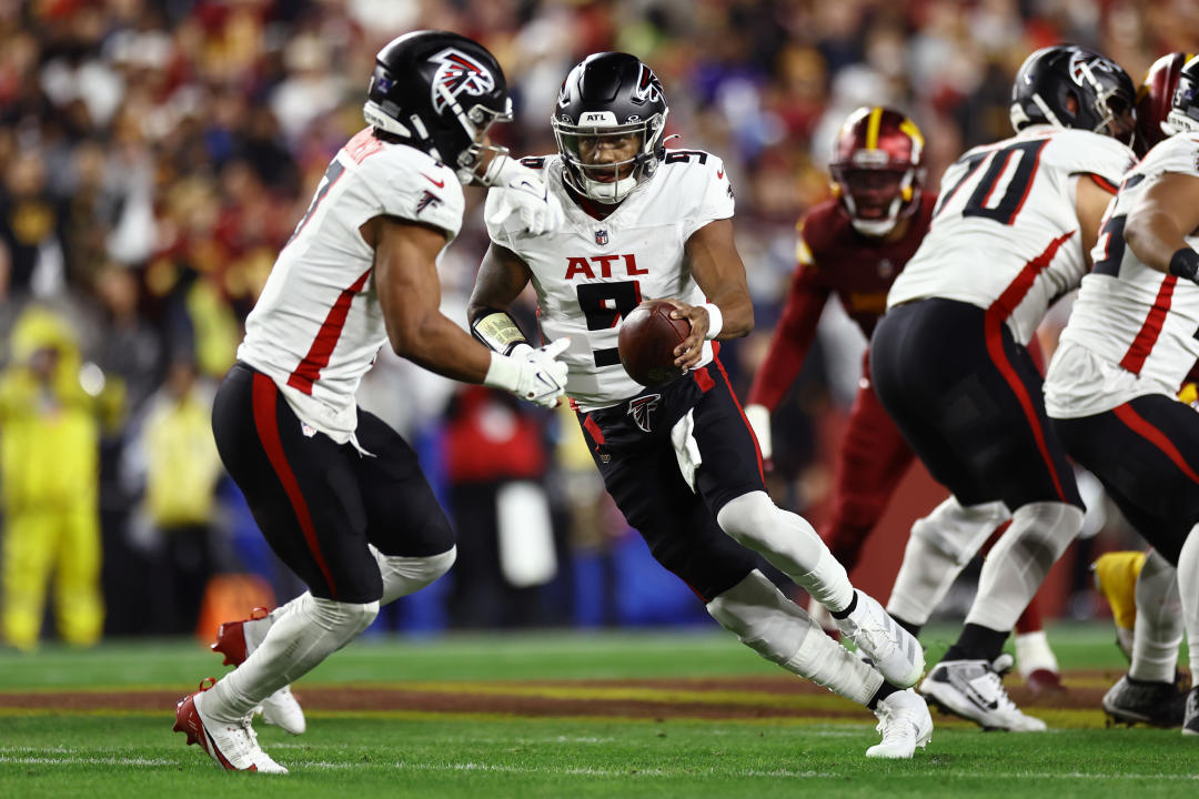 LANDOVER, MARYLAND - DECEMBER 29: Michael Penix Jr. #9 of the Atlanta Falcons hands the ball off to Bijan Robinson #7 in the first quarter against the Washington Commanders at Northwest Stadium on December 29, 2024 in Landover, Maryland. (Photo by Timothy Nwachukwu/Getty Images)