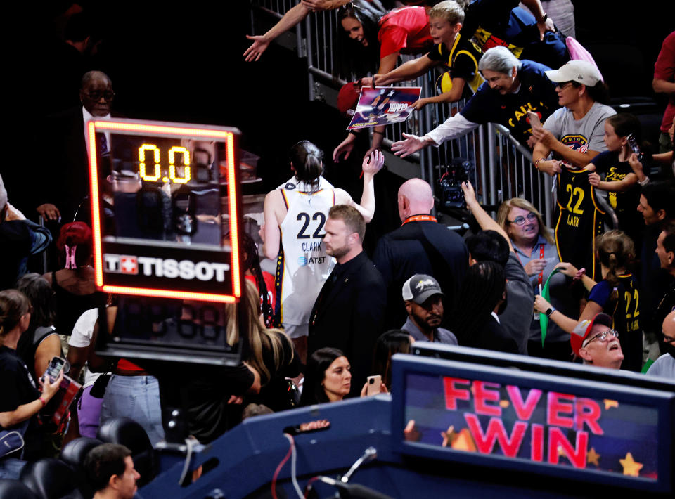 INDIANAPOLIS, IN - AUGUST 28: Indiana Fever guard Caitlin Clark (22) high fives the fans as she walks off the floor after the Indiana Fever defeat the Connecticut Sun on August 28, at Gainbridge Fieldhouse in Indianapolis, Indiana. (Photo by Brian Spurlock/Icon Sportswire via Getty Images)