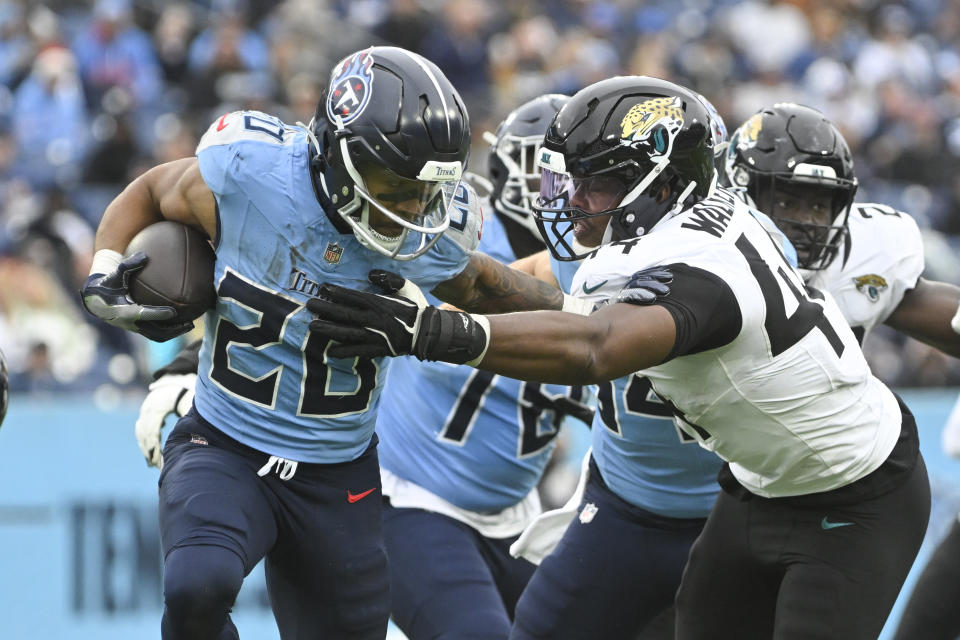 Tennessee Titans running back Tony Pollard (20) rushes with Jacksonville Jaguars defensive end Travon Walker (44) defending in an NFL football game Monday, Dec. 9, 2024, in Nashville, Tenn. (AP Photo/John Amis)