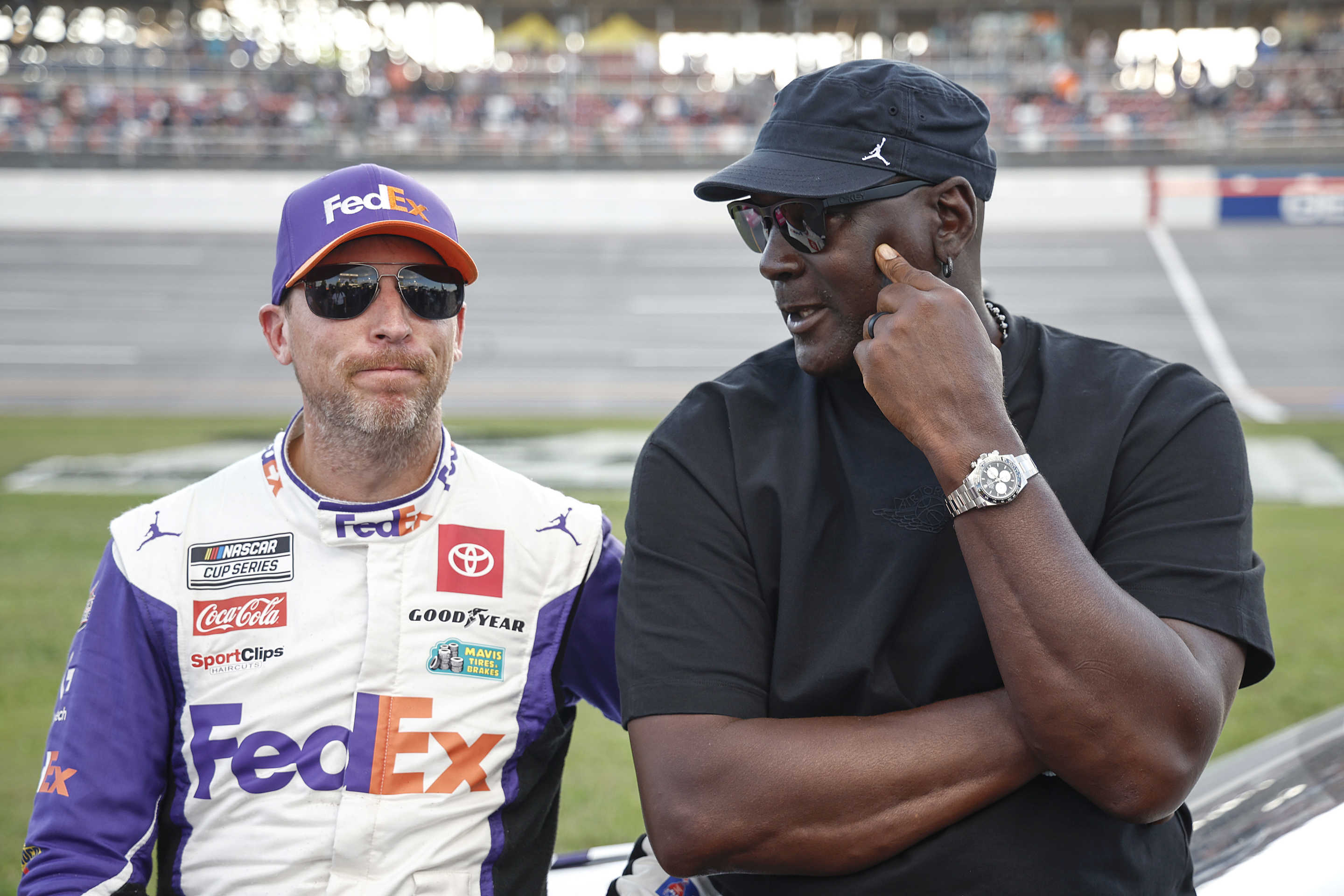 TALLADEGA, ALABAMA - OCTOBER 06: Co-owners of 23XI Racing, Denny Hamlin, driver of the #11 FedEx One Rate Toyota, and NBA Hall of Famer, Michael Jordan talk on the grid after the NASCAR Cup Series YellaWood 500 at Talladega Superspeedway on October 06, 2024 in Talladega, Alabama. (Photo by Chris Graythen/Getty Images)