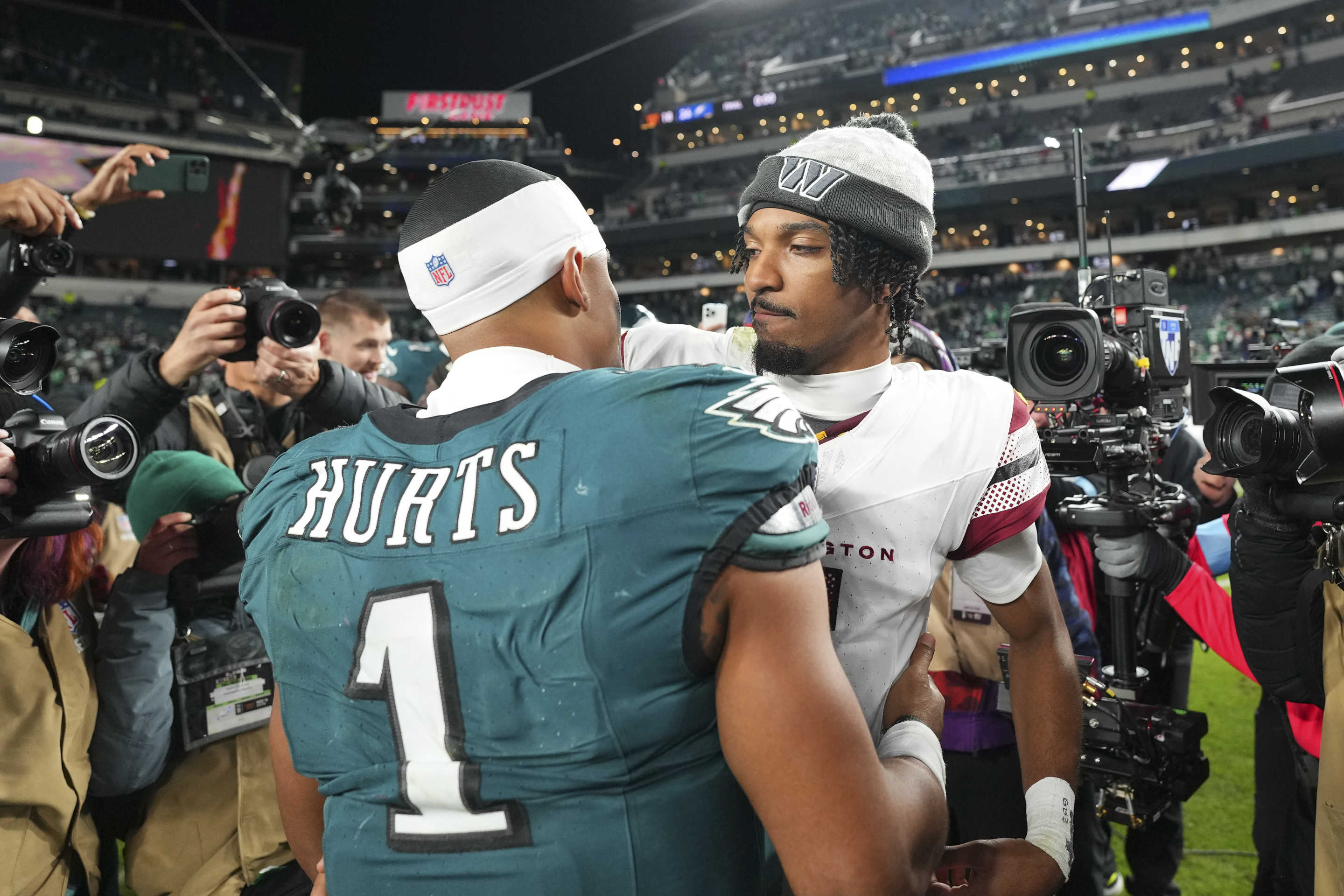 PHILADELPHIA, PENNSYLVANIA - NOVEMBER 14: Jalen Hurts #1 of the Philadelphia Eagles hugs Jayden Daniels #5 of the Washington Commanders at Lincoln Financial Field on November 14, 2024 in Philadelphia, Pennsylvania. (Photo by Mitchell Leff/Getty Images)