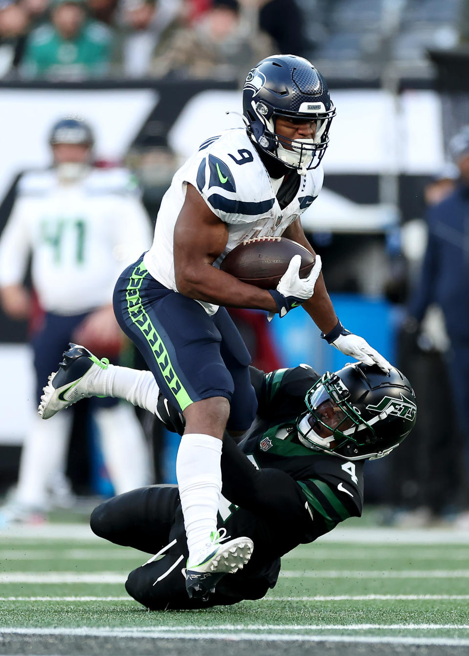 EAST RUTHERFORD, NEW JERSEY - DECEMBER 01: Kenneth Walker III #9 of the Seattle Seahawks breaks a tackle by D.J. Reed #4 of the New York Jets in the fourth quarter of a game at MetLife Stadium on December 01, 2024 in East Rutherford, New Jersey. (Photo by Luke Hales/Getty Images)