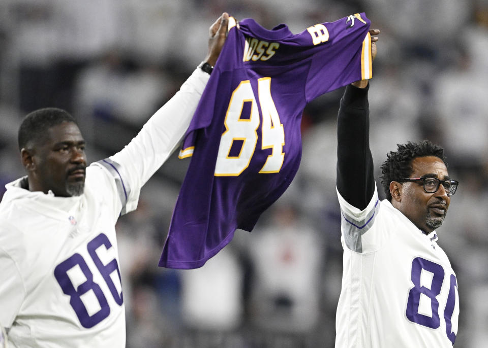 Former Minnesota Vikings Jake Reed, left, and Cris Carter hold up a Randy Moss Jersey prior to a game against the Chicago Bears. (Photo by Stephen Maturen/Getty Images)