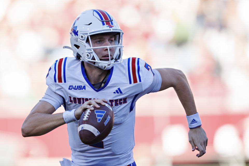 FAYETTEVILLE, ARKANSAS - NOVEMBER 23: Evan Bullock #7 of the Louisiana Tech Bulldogs rolls out to pass during a game against the Arkansas Razorbacks at Donald W. Reynolds Razorback Stadium on November 23, 2024 in Fayetteville, Arkansas. The Razorbacks defeated the Bulldogs 35-14. (Photo by Wesley Hitt/Getty Images)