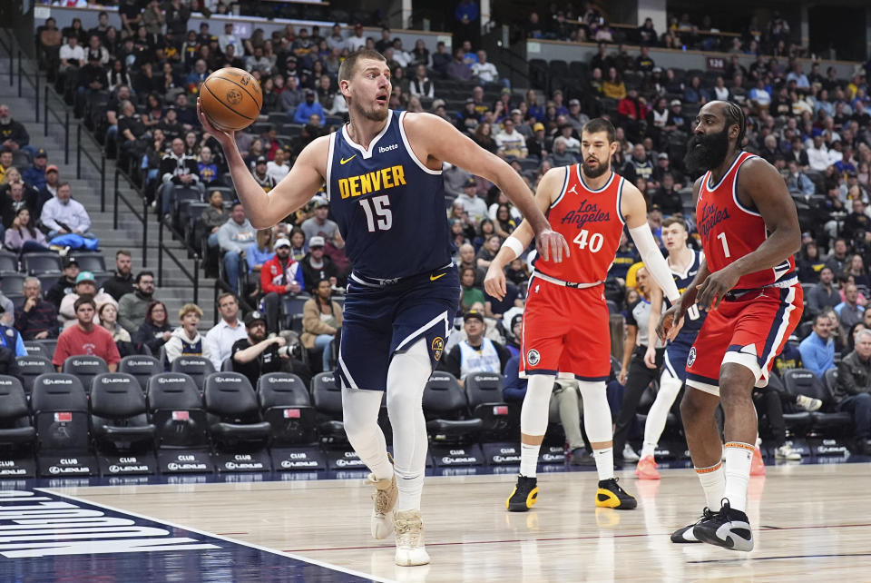 Denver Nuggets center Nikola Jokic (15), Los Angeles Clippers center Ivica Zubac (40) and guard James Harden (1) in the first half of an NBA basketball game Friday, Dec. 13, 2024, in Denver. (AP Photo/David Zalubowski)