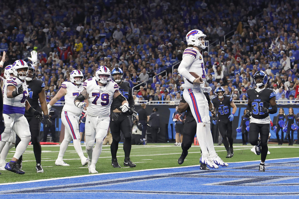 Buffalo Bills quarterback Josh Allen, foreground, celebrates after scoring against the Detroit Lions during the first half of an NFL football game, Sunday, Dec. 15, 2024, in Detroit. (AP Photo/Rey Del Rio)