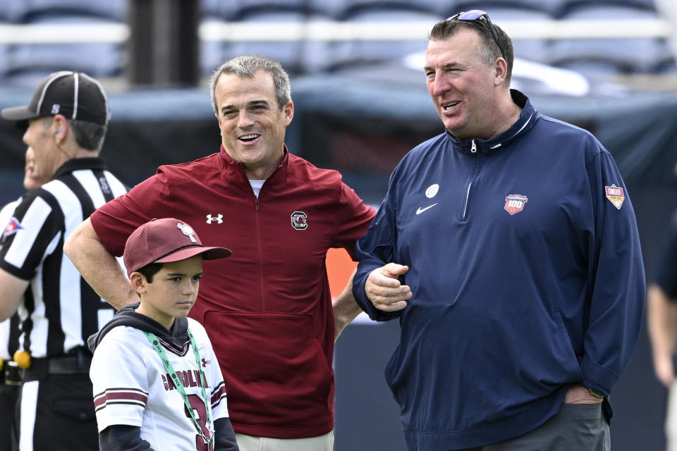 Illinois head coach Bret Bielema, right, and South Carolina head coach Shane Beamer chat on the field before the Citrus Bowl NCAA college football game, Tuesday, Dec. 31, 2024, in Orlando, Fla. (AP Photo/Phelan M. Ebenhack)