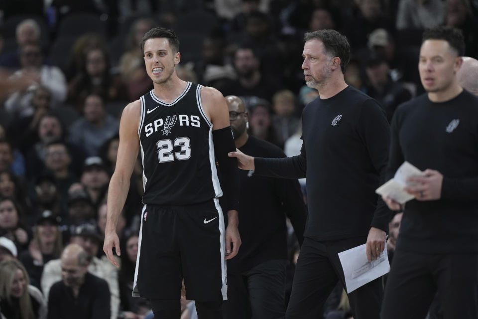 San Antonio Spurs forward Zach Collins (23) is escorted off the court after he was ejected during the first half of an NBA basketball game against the Sacramento Kings in San Antonio, Friday, Dec. 6, 2024. (AP Photo/Eric Gay)