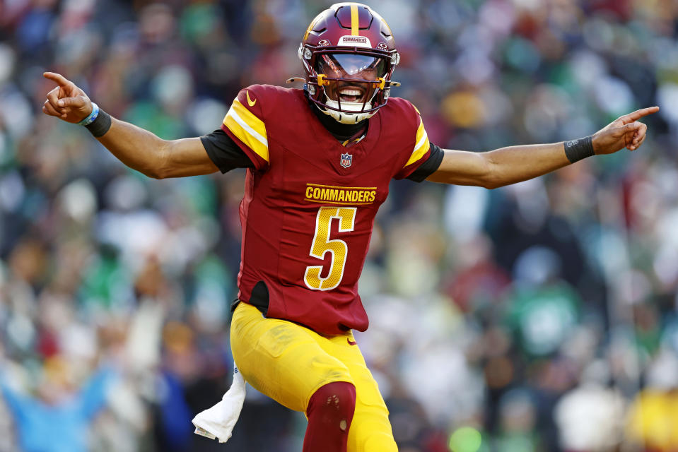 Dec 22, 2024; Landover, Maryland, USA; Washington Commanders quarterback Jayden Daniels (5) celebrates after throwing a touchdown during the fourth quarter against the Philadelphia Eagles at Northwest Stadium. Mandatory Credit: Peter Casey-Imagn Images