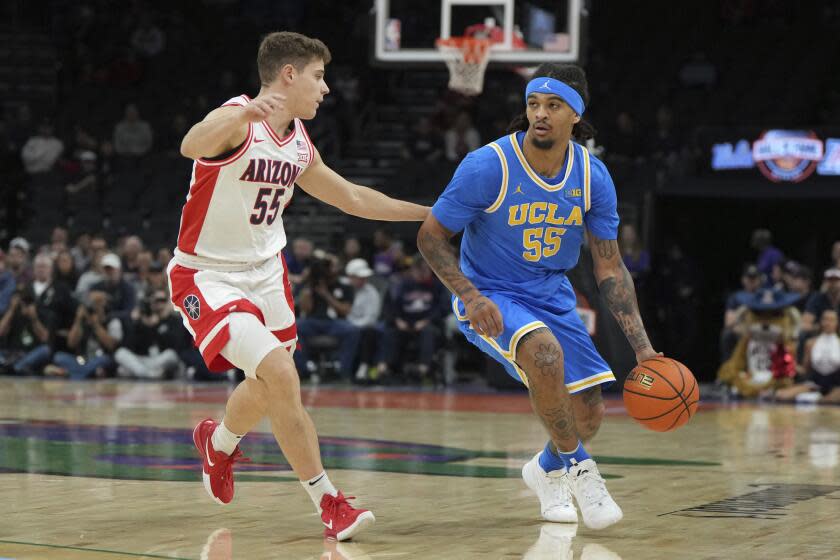 UCLA guard Skyy Clark (55) during the first half of an NCAA college basketball game against Arizona, Saturday, Dec. 14, 2024, in Phoenix. (AP Photo/Rick Scuteri)