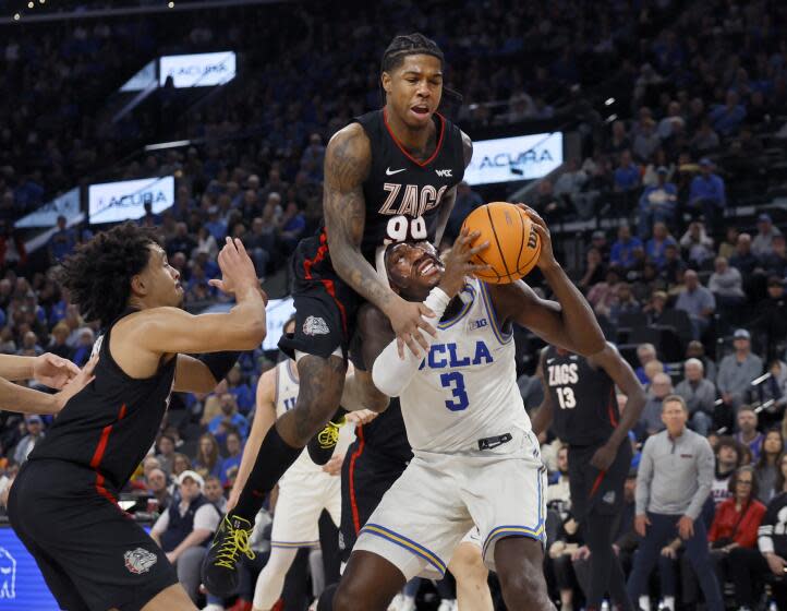 Inglewood, CA - December 28: Gonzaga guard Khalif Battle, center, #99, fouls UCLA guard/forward Eric Dailey.