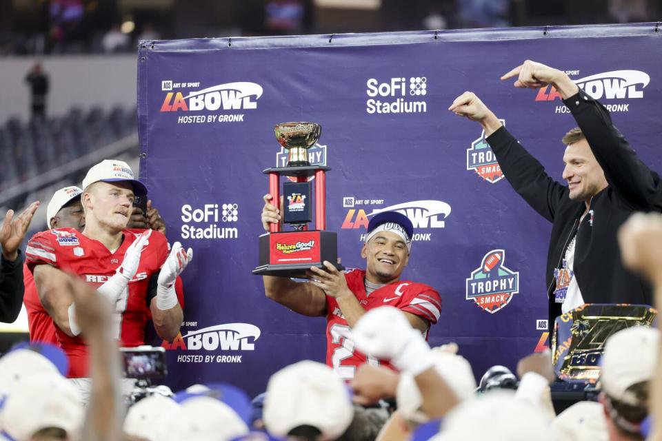 UNLV receiver Jacob De Jesus is presented with the offensive MVP trophy after UNLV's victory over California