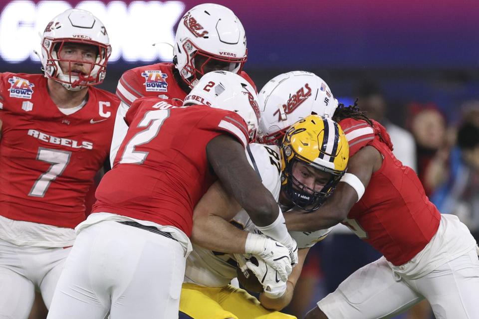 California tight end Jack Endries is tackled by UNLV's Antonio Doyle Jr. and Johnathan Baldwin during the L.A. Bowl