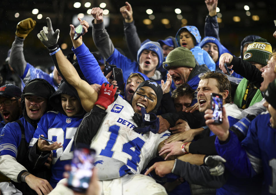 Amon-Ra St. Brown celebrates with fans in the stands after Detroit's Week 9 win over Green Bay. (Kevin Sabitus/Getty Images)